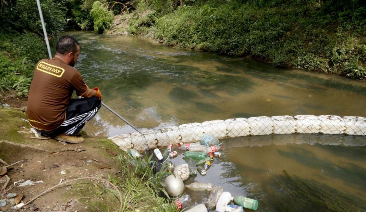 Homem cria ecobarreira caseira e retira 1 tonelada de lixo de rio